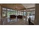 Living room with hardwood ceiling, tile floors, large windows overlooking the pool and landscaped exterior at 4872 Silverthorne Ct, Oldsmar, FL 34677