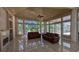 Living room with hardwood ceiling, tile floors, large windows overlooking the landscaped exterior at 4872 Silverthorne Ct, Oldsmar, FL 34677