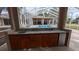 Outdoor kitchen featuring granite counters, a sink, mini fridge, and wooden cabinets at 4872 Silverthorne Ct, Oldsmar, FL 34677