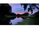 Scenic view of a pond with trees and a colorful dusk sky reflected on the calm water at 4872 Silverthorne Ct, Oldsmar, FL 34677