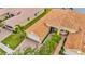 Aerial view of a yellow tile roof home with landscaping and a three car garage at 4949 Marble Springs Cir, Wimauma, FL 33598