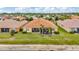 Aerial view of a home with a screen enclosed patio, lush lawn, and mature landscaping at 4949 Marble Springs Cir, Wimauma, FL 33598