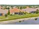 Backyard view of home, featuring a screen enclosed patio and mature landscaping, with water view at 4949 Marble Springs Cir, Wimauma, FL 33598