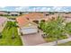 Charming single-story home with a well-manicured lawn, mature trees, and a brick-paved driveway leading to a two-car garage at 4949 Marble Springs Cir, Wimauma, FL 33598