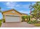 Lovely yellow single-story home featuring a brick driveway and attached two-car garage at 4949 Marble Springs Cir, Wimauma, FL 33598