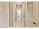 Neutral hallway with tile flooring and white doors leading to various rooms at 4949 Marble Springs Cir, Wimauma, FL 33598