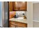 Stylish kitchen counter with granite countertops, mosaic tile backsplash, and wood cabinetry at 4949 Marble Springs Cir, Wimauma, FL 33598