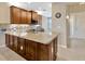 Kitchen island featuring granite countertops, stainless steel sink, and dark wood cabinets at 4949 Marble Springs Cir, Wimauma, FL 33598