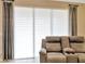 Modern living room with reclining sofa, custom window shades, and neutral decor at 4949 Marble Springs Cir, Wimauma, FL 33598