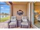 Relaxing screened patio with wicker furniture and decorative art, overlooking serene water view at 4949 Marble Springs Cir, Wimauma, FL 33598