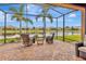 Screened patio with comfortable seating overlooking the tranquil pond and manicured backyard at 4949 Marble Springs Cir, Wimauma, FL 33598