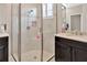 Close-up of updated shower with tiled walls, glass door, and chrome fixtures in neutral toned bathroom at 4949 Marble Springs Cir, Wimauma, FL 33598