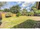 Expansive grassy backyard enclosed by wood fencing with mature trees at 5101 13Th S Ave, Gulfport, FL 33707