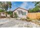 Home exterior with a covered front porch and wooden fence, showcasing curb appeal with trees and blue skies at 5101 13Th S Ave, Gulfport, FL 33707