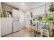 Bright laundry room with tile floors, a stacked washer dryer, and a table with plants and hanging planters at 5101 13Th S Ave, Gulfport, FL 33707