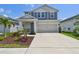Charming two-story home featuring a well-manicured lawn, covered porch and a two car garage at 5437 Del Coronado Dr, Apollo Beach, FL 33572