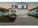 Charming two-story home featuring a well-manicured lawn, covered porch and a two car garage at 5437 Del Coronado Dr, Apollo Beach, FL 33572
