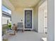 Cozy front porch featuring rocking chairs, a small table and a stylish front door with glass panels at 5437 Del Coronado Dr, Apollo Beach, FL 33572