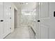 Hallway leading to a bathroom with glass enclosed shower and dual vanity, providing ample space at 5437 Del Coronado Dr, Apollo Beach, FL 33572