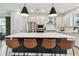 Modern kitchen featuring a large island with seating, stainless steel appliances, and stylish pendant lighting at 5437 Del Coronado Dr, Apollo Beach, FL 33572