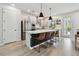 Bright kitchen with a center island, stainless steel appliances, sleek white cabinets, and view to a pool through the glass door at 5437 Del Coronado Dr, Apollo Beach, FL 33572