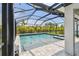 Beautiful pool area enclosed in a screened lanai features blue water, a spa, and lush landscaping at 5437 Del Coronado Dr, Apollo Beach, FL 33572