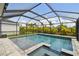 The screened-in pool features blue water, a spa, and lush landscaping surrounded by a paver patio at 5437 Del Coronado Dr, Apollo Beach, FL 33572