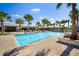 A luxurious community pool sits next to the clubhouse with palm trees and lounge chairs for residents at 5437 Del Coronado Dr, Apollo Beach, FL 33572