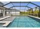 Outdoor pool with volleyball net inside screened-in lanai with paver patio at 5437 Del Coronado Dr, Apollo Beach, FL 33572