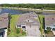 Stunning aerial view of a modern home with a paved driveway, well-maintained landscaping, and a tranquil lake view at 5477 Wayfarer Ave, Apollo Beach, FL 33572