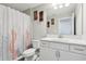 Clean bathroom featuring a toilet, a vanity with a marble top, and a floral-patterned shower curtain at 5477 Wayfarer Ave, Apollo Beach, FL 33572