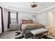 Comfortable bedroom with wood-look floors, decorative ceiling, and a cozy bench at the foot of the bed at 5477 Wayfarer Ave, Apollo Beach, FL 33572