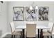 Close-up shot of a dining area with chairs, marble table, modern art, and pendant lighting at 5477 Wayfarer Ave, Apollo Beach, FL 33572