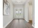 Elegant entryway with decorative glass doors, hardwood flooring, and a tray ceiling, offering a grand welcome at 5477 Wayfarer Ave, Apollo Beach, FL 33572
