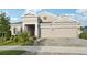 Beautiful home exterior with a three-car garage, manicured lawn, and lush landscaping, showcasing curb appeal at 5477 Wayfarer Ave, Apollo Beach, FL 33572