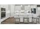 A modern, all-white kitchen features a large island with seating and stainless steel appliances at 5477 Wayfarer Ave, Apollo Beach, FL 33572
