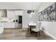 Bright kitchen with white cabinets, stainless steel appliances, and a dining area featuring modern art at 5477 Wayfarer Ave, Apollo Beach, FL 33572