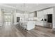 Modern kitchen featuring white cabinets, a center island with seating, stainless steel appliances, and wood flooring at 5477 Wayfarer Ave, Apollo Beach, FL 33572