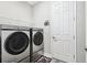 Modern laundry room with front-load washer and dryer, shelving, and stylish decor at 5477 Wayfarer Ave, Apollo Beach, FL 33572