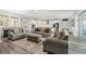 Cozy living room featuring comfortable sofas, hardwood flooring, neutral decor, and an open view to the kitchen and dining at 5477 Wayfarer Ave, Apollo Beach, FL 33572