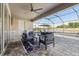 A cozy covered patio features a ceiling fan and outdoor furniture overlooking a pool and lake view at 5477 Wayfarer Ave, Apollo Beach, FL 33572