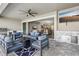 A cozy covered patio features a ceiling fan and outdoor furniture with a fireplace and exterior kitchen at 5477 Wayfarer Ave, Apollo Beach, FL 33572