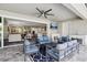 A cozy covered patio features a ceiling fan and outdoor furniture with a fireplace and exterior kitchen at 5477 Wayfarer Ave, Apollo Beach, FL 33572