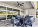 A cozy covered patio features a ceiling fan and outdoor furniture with a fireplace and exterior kitchen at 5477 Wayfarer Ave, Apollo Beach, FL 33572