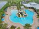 Aerial view of a resort-style pool with dual slides, lounging areas, and lush landscaping at 5477 Wayfarer Ave, Apollo Beach, FL 33572