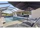 Relaxing pool with a screened enclosure, summer kitchen, and outdoor seating area, perfect for enjoying the outdoors at 5477 Wayfarer Ave, Apollo Beach, FL 33572