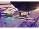 Screened-in pool and spa with outdoor kitchen, and lounge seating under a sunset at 5477 Wayfarer Ave, Apollo Beach, FL 33572
