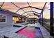 Screened-in pool and spa with outdoor kitchen, and lounge seating under a sunset at 5477 Wayfarer Ave, Apollo Beach, FL 33572