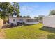 Spacious backyard featuring a fire pit, enclosed patio, lush green grass and a storage shed at 5932 Mckee Lake N Dr, St Petersburg, FL 33709