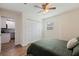 Bedroom features wood floors, ceiling fan, closet, and adjacent kitchen at 5932 Mckee Lake N Dr, St Petersburg, FL 33709